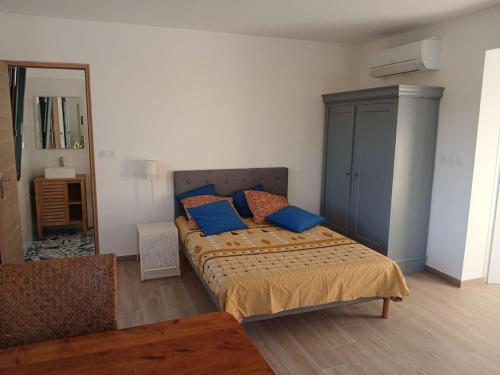 une chambre avec un lit avec des oreillers bleus dessus dans l'établissement Domaine en pleine nature et tout près de la plage, à Sanary-sur-Mer