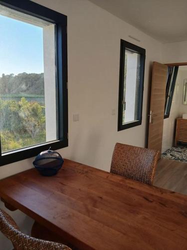 une salle à manger avec une table en bois et une grande fenêtre dans l'établissement Domaine en pleine nature et tout près de la plage, à Sanary-sur-Mer