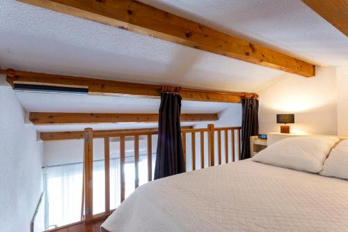 une chambre avec un lit blanc et une fenêtre dans l'établissement Villa 40m2 cosy avec piscine, clim, parking privé, à La Grande Motte