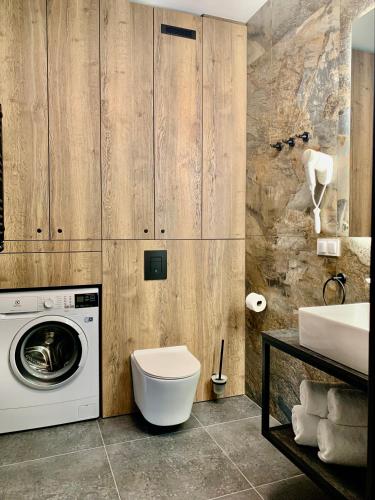 a bathroom with a washing machine and a sink at REMAR - Apartamenty z widokiem na Jezioro Biale in Augustów