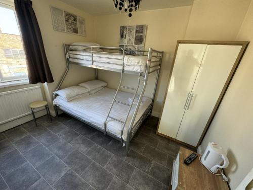 a room with two bunk beds and a refrigerator at Clacton Guest House in Clacton-on-Sea
