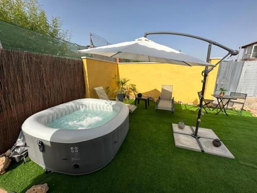 a hot tub on the grass with an umbrella at Casa Salud in Piera