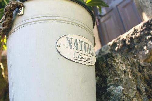 a white cylinder with a sign that says natta village obey at Casa Vouzelinha in Vouzela