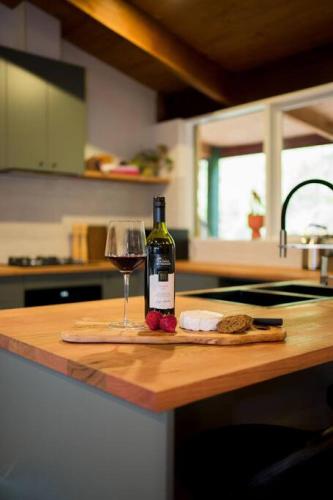 a bottle of wine and a glass on a kitchen counter at Healesville Mud Brick Hideaway in Healesville
