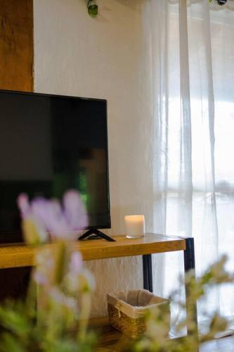 a living room with a television and a table with a candle at Healesville Mud Brick Hideaway in Healesville