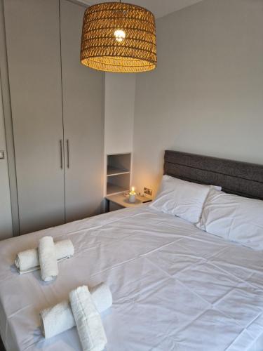 a bedroom with a white bed with towels on it at Cozy Apartment in Asprovalta