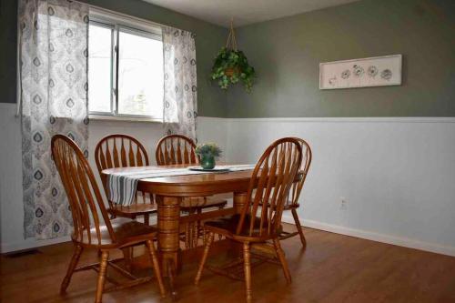 a dining room with a wooden table and chairs at Cozy Garden House in Adrian