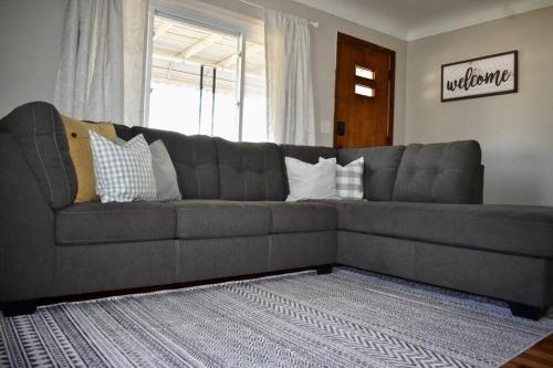 a gray couch with pillows on it in a living room at Cozy Garden House in Adrian