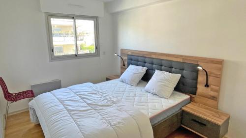 - une chambre avec un grand lit, une fenêtre et une chaise dans l'établissement La Palmeraie, à Sainte-Maxime