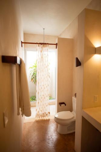 a bathroom with a toilet and a window at 97985 Stunning beachfront Suites Wi-Fi East of Progreso in Chicxulub