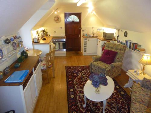 a living room with a table and a kitchen at Walkers Retreat in Holne