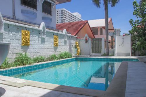 a swimming pool in front of a building at Royal Adobe Pool Villa in Jomtien Beach