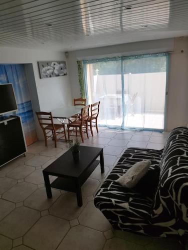 un salon avec un canapé et une table dans l'établissement Bas de villa climatisé avec coin terrasse, à Sanary-sur-Mer