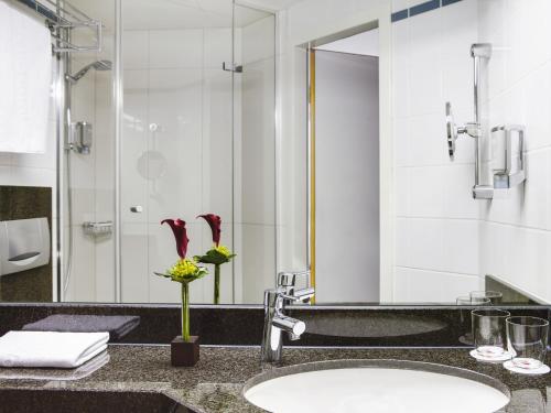 a bathroom with a sink and a mirror at IntercityHotel Nürnberg in Nürnberg