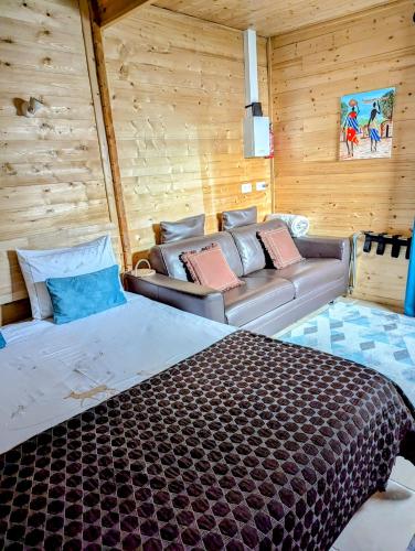 une chambre avec un lit et un canapé dans une pièce dans l'établissement Les Chambres D'oriane, à Chessy