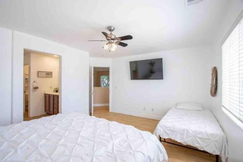 a white bedroom with a bed and a ceiling fan at 180 Perfect for large groups in Coachella