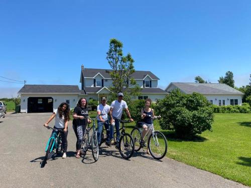 a group of people standing with bikes in front of a house at Graham Inn in New Glasgow
