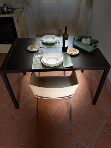 a black table with plates of food and a bottle of wine at My Tuscany Relais in Altopascio