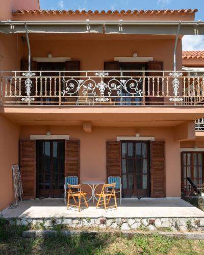 a house with two chairs and a balcony at Kokkini Peach Budget in Kokkínion