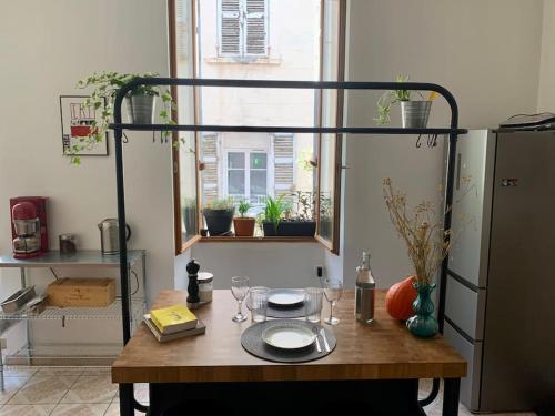 une cuisine avec une table avec des verres et une étagère dans l'établissement Petit Boucan 47m2 Dans le coeur du Panier, à Marseille