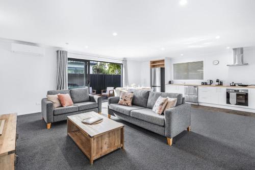 a living room with two couches and a coffee table at King Bed, Modern and Peaceful - By KOSH BNB in Hamilton