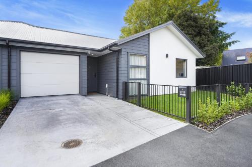 a house with a white and black garage at King Bed, Modern and Peaceful - By KOSH BNB in Hamilton