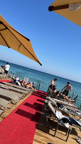 a group of people laying on chairs on the beach at THE LEA HOTELS & SUITE in Didim