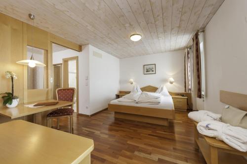ein Hotelzimmer mit einem Bett und einem Sofa in der Unterkunft Hotel Gampen in Sulden