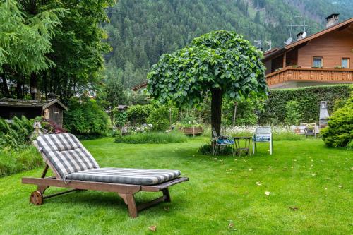 a chair sitting in the grass in a yard at Appartments Reichegger in Villa Ottone