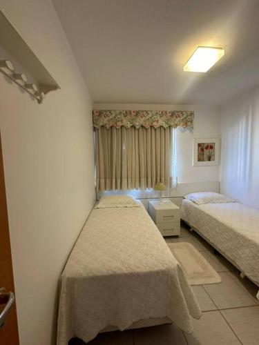 a bedroom with two beds and a window at Caldas Novas - Prive das Thermas II - Apto 3 quartos - Parque Aquático in Caldas Novas