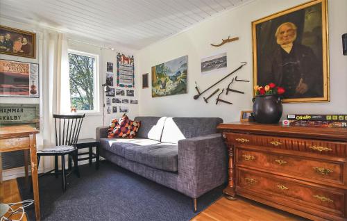 a living room with a couch and a painting on the wall at 2 Bedroom Beautiful Home In Fjällbacka in Fjällbacka