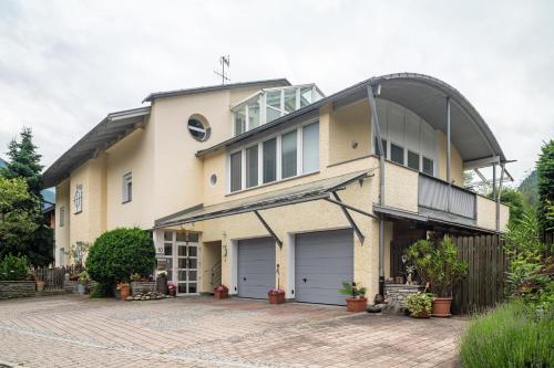 a house with two garage doors on a brick driveway at Appartments Reichegger in Villa Ottone