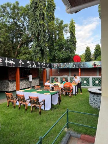 a group of people sitting around a table in a yard at Kilimanjaro Trekcity Hostel in Moshi