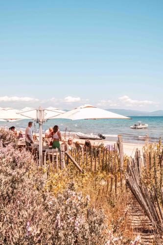 a group of people sitting at a table on the beach at Salines in Hyères