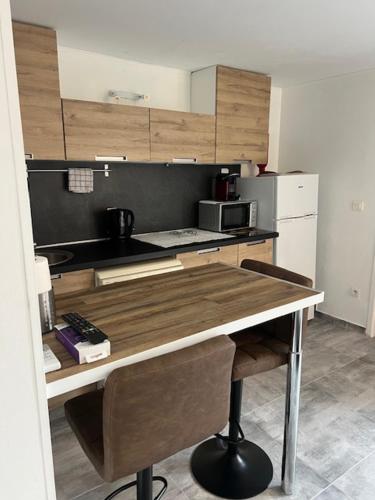 - une cuisine avec une table en bois et un four micro-ondes dans l'établissement Cavalière studio 2 pers terrasse, au Lavandou