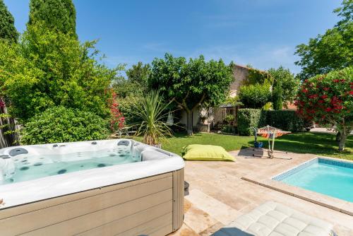 - un bain à remous dans une cour à côté d'une piscine dans l'établissement Le Mas, à Graveson