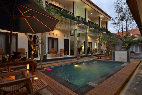a swimming pool in front of a house at Pujihouse One in Legian