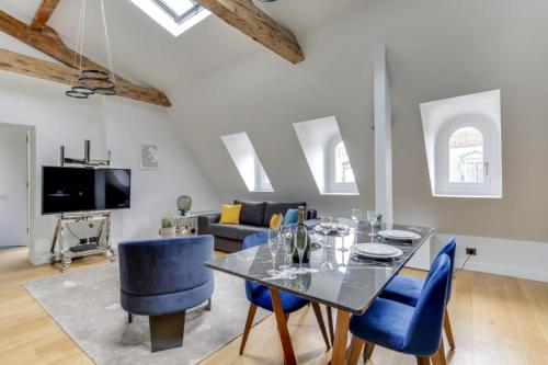 un salon avec une table et des chaises bleues dans l'établissement Elegant Home 2BDR 6P Near Champs Elysées, à Paris