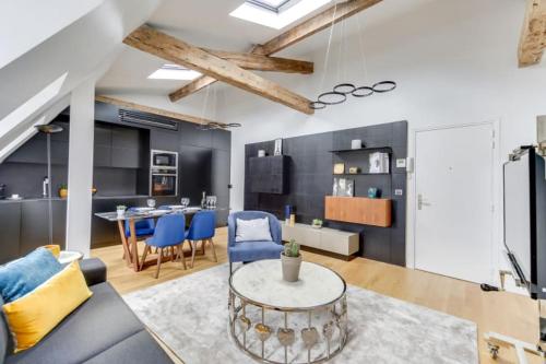 un salon avec une table et des chaises bleues dans l'établissement Elegant Home 2BDR 6P Near Champs Elysées, à Paris