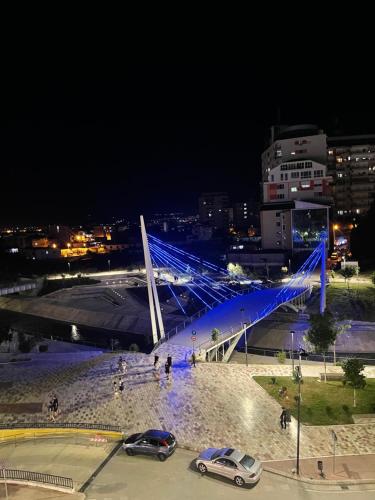 a bridge with blue lights in a city at night at Albora Guest House 3 in Fier