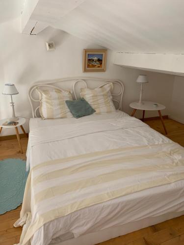 - une chambre avec un lit blanc et 2 tables dans l'établissement Oasis de verdure, à Sanary-sur-Mer