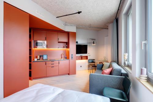 a living room with a couch and a kitchen at DEIN APART München in Munich