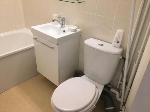 une salle de bain avec des toilettes blanches et un lavabo dans l'établissement Charmant Studio vue Port, à Courseulles-sur-Mer