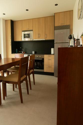 a kitchen with a table and chairs and a refrigerator at Apartamentos Camino Inglés II in Ordes