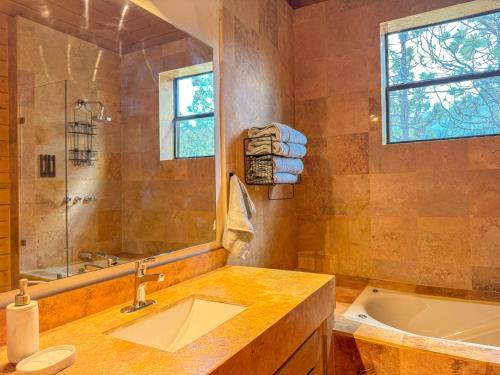 a bathroom with a tub and a sink at Cabaña Ohana in Mesa de las Tablas