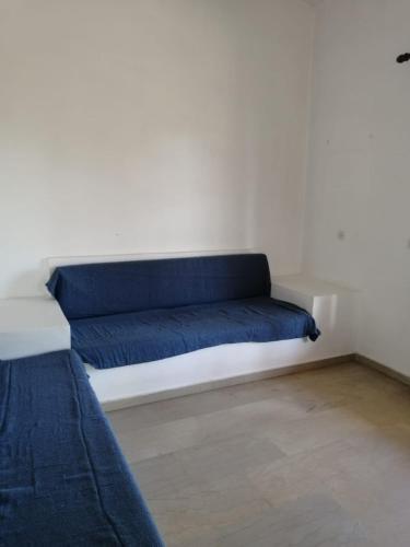 a blue couch sitting against a white wall at Apollo Greekgod Apartments in Sidari