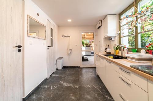 a kitchen with white cabinets and a concrete floor at Wynajem grupowy Szansa in Mrągowo