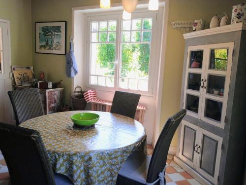 - une table à manger avec des chaises et un bol vert dans l'établissement Maison de charme classée 4 étoiles centre ville vannes Garage WIFI, à Vannes