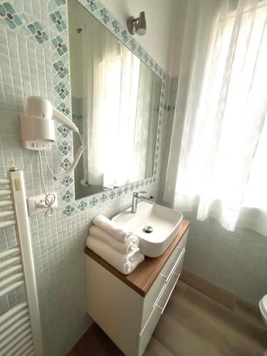 a white bathroom with a sink and a mirror at Airoldi Palace Apartment in Chioggia