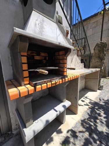 a outdoor pizza oven sitting next to a staircase at Casa da Capela in Entre Ambos os Rios